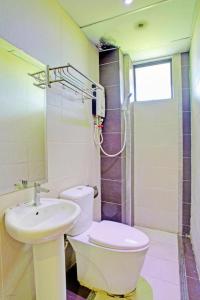 a bathroom with a toilet and a sink at OYO 90597 Delightful Holiday Inn in Ranau
