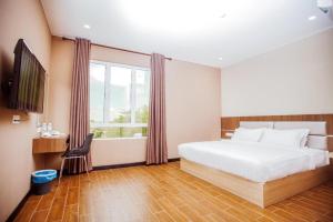 a bedroom with a white bed and a window at Friendly Hotel in Kudat +53 photos
