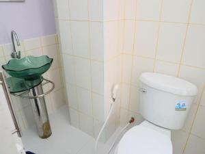 a bathroom with a toilet and a green sink at Baan Taklom Chomtalay in Ban Sahakham +41 photos