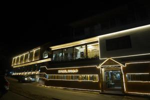 un edificio illuminato di notte con la scritta aigersound sopra di Hotel Auli D a Joshīmath