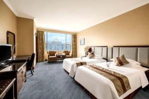 a hotel room with two beds and a television at Chongqing Sunshine Continental Grand Hotel in Chongqing +95 photos
