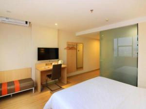 a bedroom with a bed and a desk and a television at 7 Days Premium Zhuhai Gongbei Light Railway Branch in Zhuhai