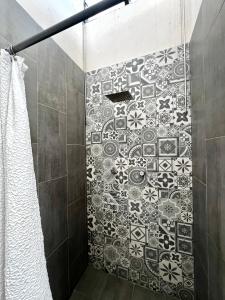 a bathroom with a shower with a mosaic tile wall at KAVA lofts in El Pueblito