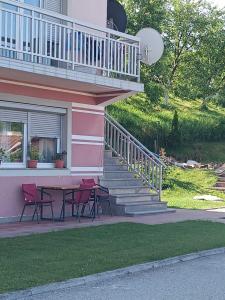 a porch with a table and chairs next to a house at Stan na dan - apartman Lara in Pale