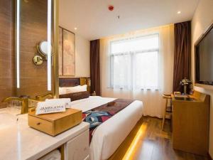 a hotel room with two beds and a television at James Joyce Coffetel· Hefei Anhui Agricultural University in Hefei
