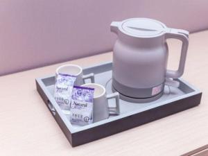 ein Tablett mit einem Teekessel und Tassen darauf in der Unterkunft Lavande Hotel Guangzhou Zengchen Xintang Light Railway Station in Zhongtang