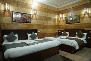 due letti in una stanza con pareti in legno di Hotel Auli D a Joshīmath