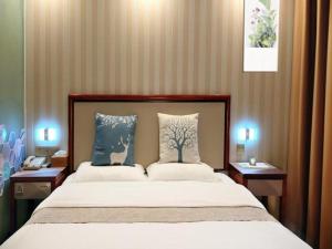 a bedroom with a large bed with two pillows at GreenTree Inn Zhenjiang Center Street No.1 Peoples Hospital Express Hotel in Zhenjiang +198 photos