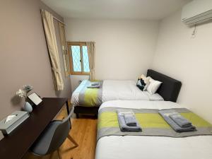 a small room with two beds and a desk and a desk at nestay suite tokyo mejiro in Tokyo +72 photos