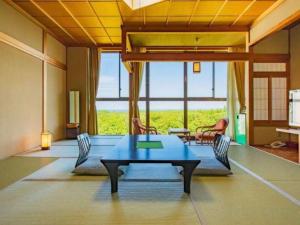 a room with a table and chairs and a large window at Oga Seiko Grand Hotel in Oga
