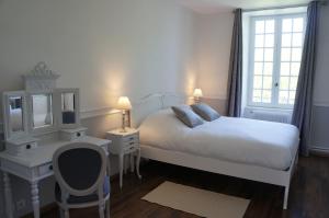 a white bedroom with a bed and a desk and a mirror at Manoir 1685 Saint Malo in Saint Malo