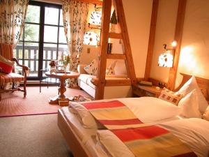 a bedroom with a bed and a ladder and a chair at Hotel Jagdhof Glashütte in Bad Laasphe +56 photos