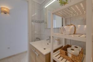 un bagno bianco con lavandino e specchio di DIANA-Moderne Ferienwohnung direkt am Strand,Klima, Wifi,zentrale Lage, Supermärkte-Shops-Restaurants fussläufig a Alcudia