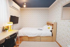 Un dormitorio pequeño con una cama con una pared de azulejos. en 레토하우스, en Incheon