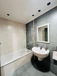 a bathroom with a sink and a bath tub and a sink at La Puerta de Logroño, con piscina y garaje! in Logroño