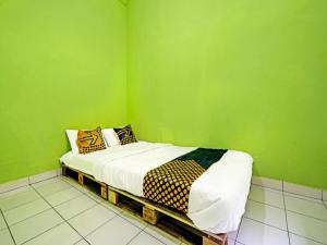 バンドンにあるSPOT ON 91325 Pondok Hijau Guest House Syariahの緑の壁のベッドルーム1室、ベッド1台(枕付) +51枚の写真