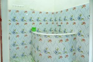 a bathroom with blue flowers on the wall at Hotel O Penginapan Indola Near Masjid Al Muhtadin in Muaradua