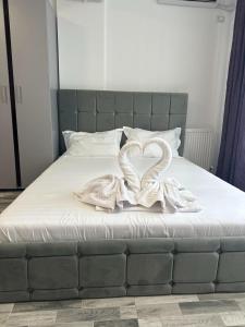 a bed with two white swans forming a heart at DAW Studio in Mamaia Nord