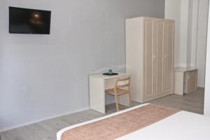 a bedroom with a desk and a white wall at Brilliant Camere in Trieste