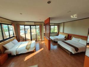 a large room with two beds and windows at Kwan Phayao Villa in Phayao