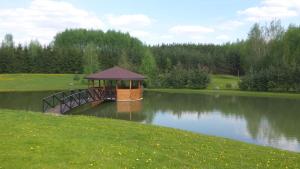 a gazebo on a bridge over a lake at Country Houses Vidų Sodyba in Utena