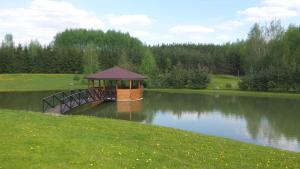 un cenador en un puente sobre un lago en Country Houses Vidų Sodyba, en Utena