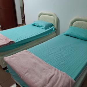 Dos camas una al lado de la otra en una habitación. en New mohastel, en Mascate