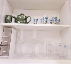 a shelf with glasses and a tea pot and vases at 스테이블홈 수서역 1분 in Seoul