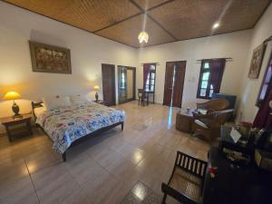 a bedroom with a bed and a living room at Rambutan Hotel in Lovina