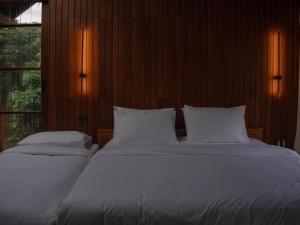 a bedroom with two beds with white sheets and a window at Ruedufon- Private Nature Retreat in Chiang Dao in Ban Tham