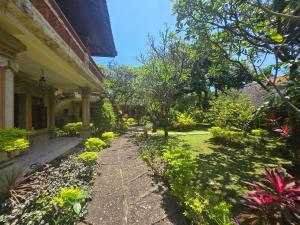 a garden in front of a house at Rambutan Hotel in Lovina