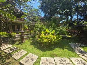 a garden in front of a house at Rambutan Hotel in Lovina