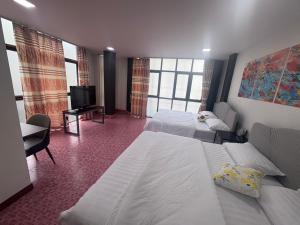 una camera d'albergo con due letti e una TV a schermo piatto di Destiny House Hostel a Hat Yai