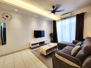 a living room with a couch and a flat screen tv at Malacca 3 bedroom Seri Serindit 07 in Malacca