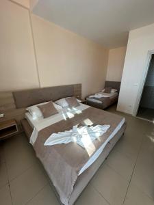 a bedroom with two beds with towels on them at LA PLAYA - Seaside Guest Room in Durrës