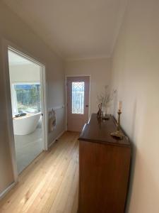 an empty room with a bath tub and a wooden floor at Livingstone-Omeo Hideaway in Omeo +44 photos