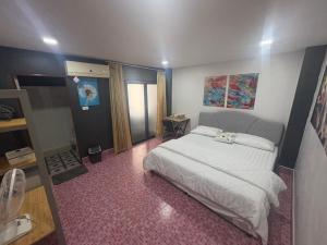 a bedroom with a large white bed in it at Destiny House Hostel in Hat Yai
