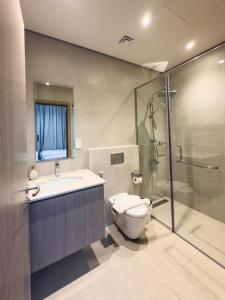 a bathroom with a toilet and a sink and a shower at Nasma Luxury Stays - Opulent Family Escape in Marbella RAK in Ras al Khaimah +66 photos