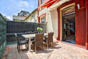 a patio with a table and chairs and a fence at VILLA 139 LA VAGUE - FRONT DE MER - appartement contemporain et terrasse sur cour - 2 à 6 personnes - Rez-de-chaussée in Houlgate