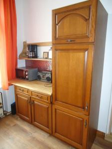 einen großen Holzschrank in einer Küche mit Mikrowelle in der Unterkunft Apartment Harmonia in Franzensbad