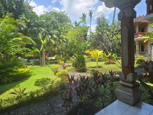a garden in front of a house at Rambutan Hotel in Lovina