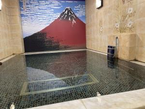 een badkamer met een douche en een muurschildering van de bergen bij Capsule Inn Kinshicho in Tokyo