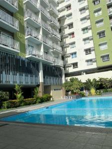 a swimming pool in front of a large apartment building at Mesatierra, Davao - Condo for Rent in Davao City