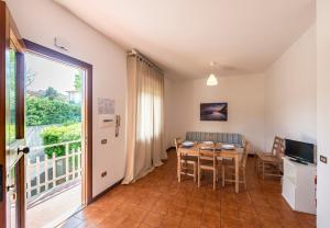 a dining room with a table and a balcony at Caletta Apartments in Castiglioncello