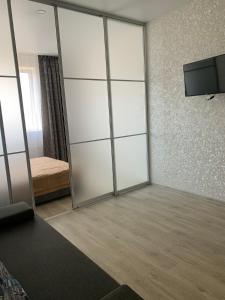 a room with a large glass closet with a television at 51 жемчужина Аркадія in Odesa