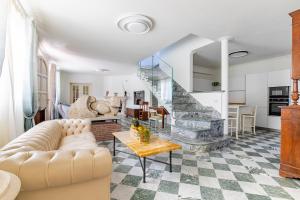 een woonkamer met een bank en een trap bij Luxury Marble House in Pietrasanta