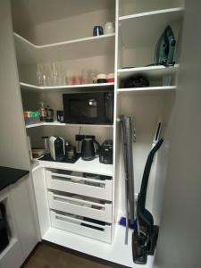 a kitchen with white shelves and a kitchen utensils at Long Dog Studio - Central city in Hamilton +11 photos