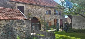 an old stone house with a gate and a fence at La Maison de Claire in Flavigny-sur-Ozerain