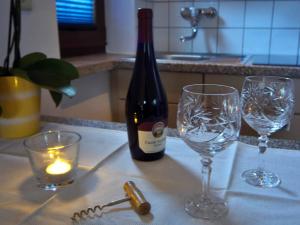una botella de vino y dos copas de vino en una barra en Separatè im Haus Carmen, en Schrebitz