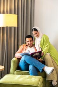 a woman standing next to a man reading a book at Hyatt Regency Baku in Baku +94 photos